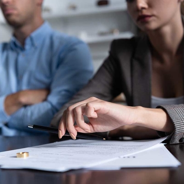 Divorced couple sitting at a table reviewing divorce papers