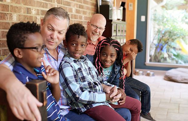 Dads sitting on porch with kids