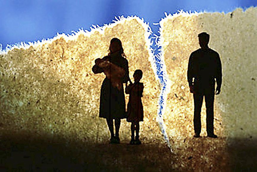 Woman holding a baby and little kid next to her