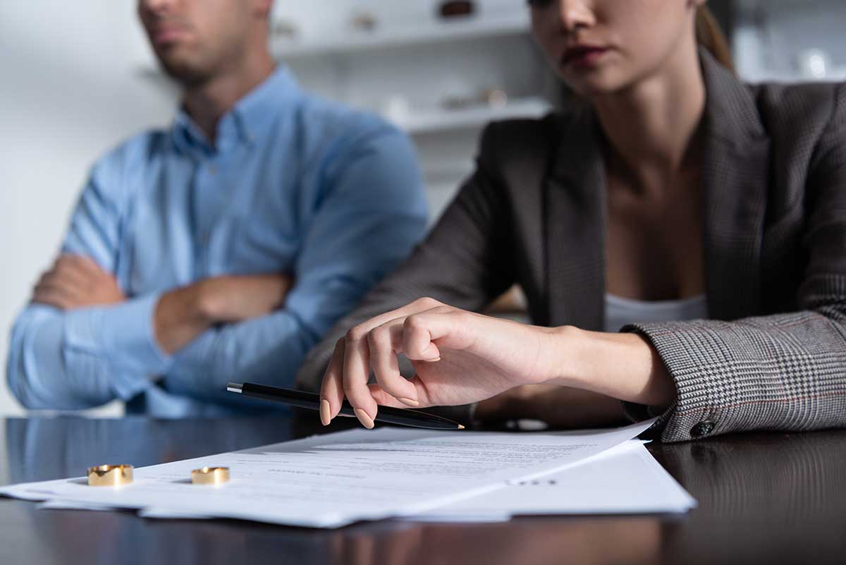 Divorced couple sitting at a table reviewing divorce papers