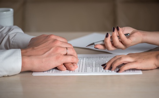 Divorced couple with divorce documents, one spouse refusing to sign