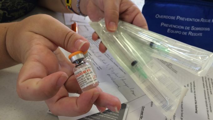 Woman holding medication and needles