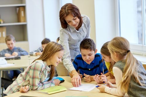 Teacher pointing at a piece of paper with students